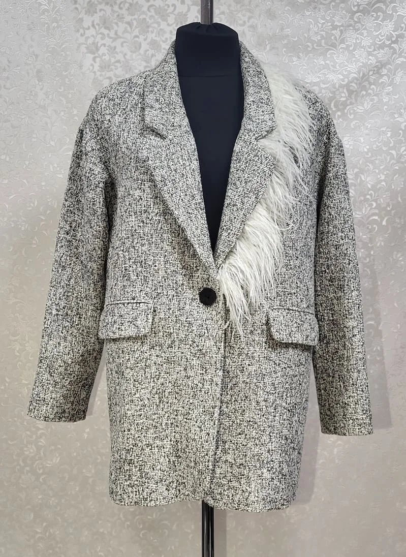 An example of updating old clothes is a gray coat with a decorative detail